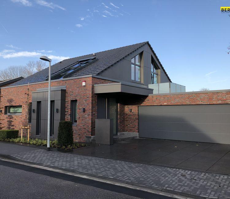 Modernes Einfamilienhaus mit Ziegelfassade und großem Garagentor