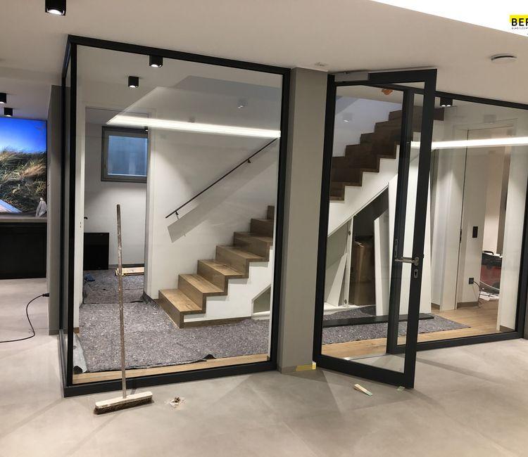 Innenansicht eines modernen Treppenhauses mit Glastrennwänden und Türanlage