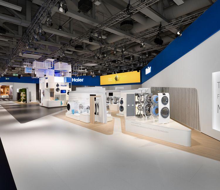 Überblick über den Haier-Messestand mit beleuchtetem Markenlogo und Produktinseln