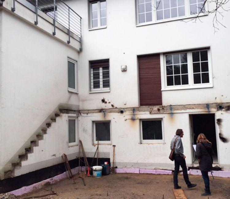 Ursprünglicher Zustand des Gebäudes vor dem Umbau, mit alter Fassade und sichtbaren Vorbereitungen für den Anbau.