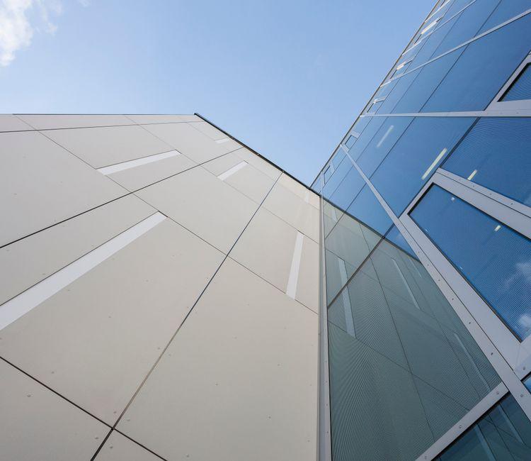 Ansicht der Glasfassade von C.A.R.L. mit Blick in den Himmel.