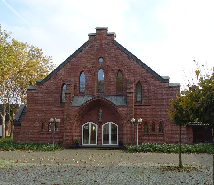 Frontalansicht des Haupteingangs der Kirche St. Josef mit markanter Backsteinfassade.