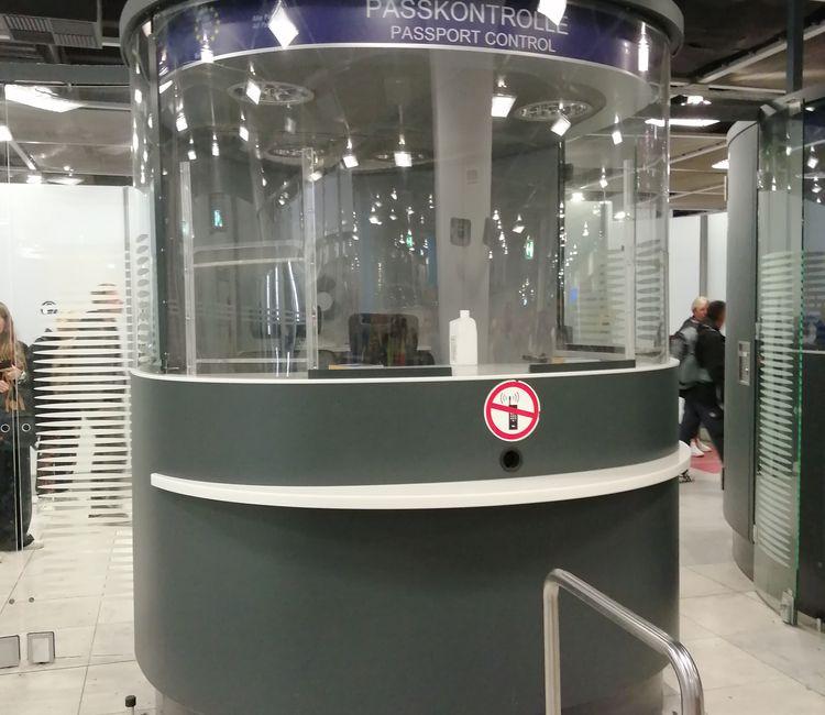 Leere Passkontrollkabine mit klarer Beschriftung „Passport Control“.