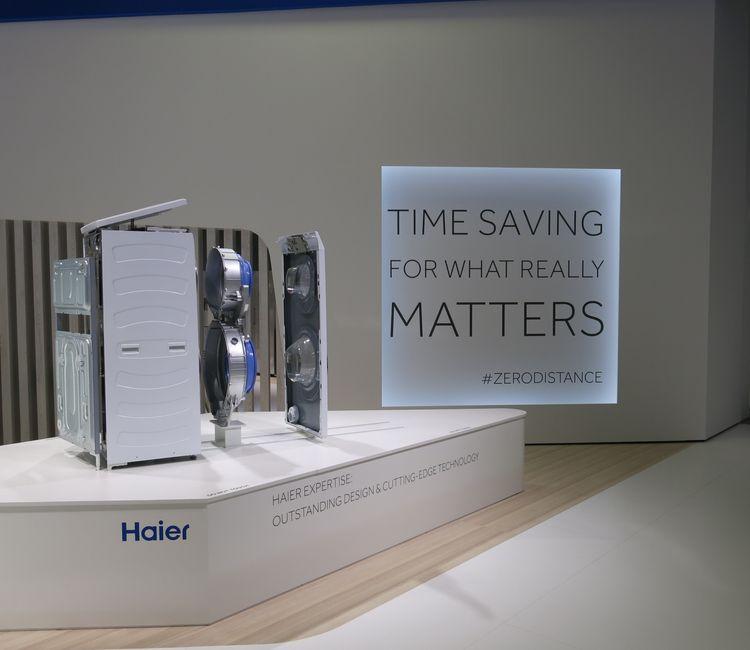 Haier-Ausstellungsstück mit zerlegter Waschmaschine und Leuchtschrift „TIME SAVING“