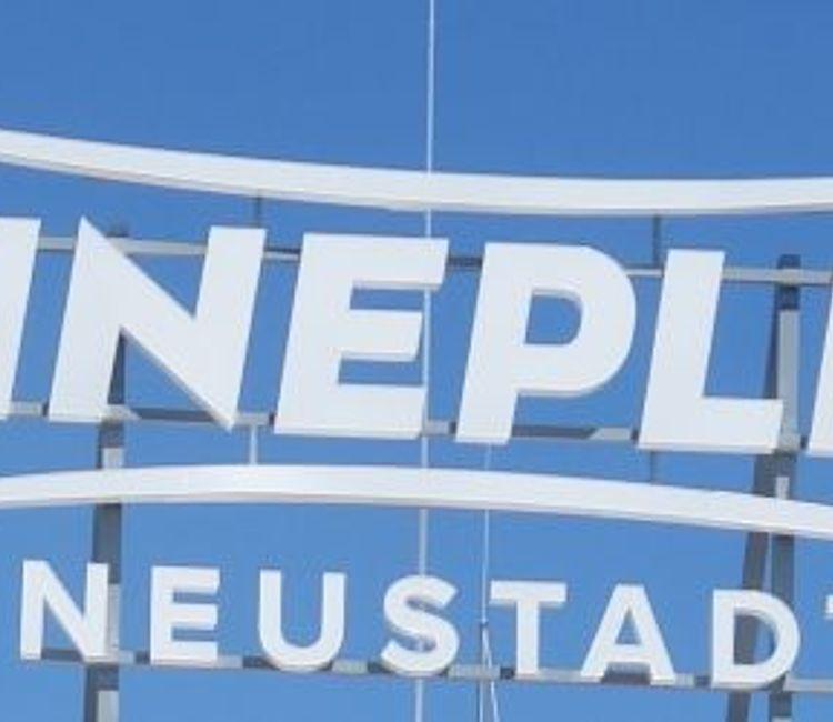 Nahaufnahme des Cineplex-Neustadt-Logos vor blauem Himmel.