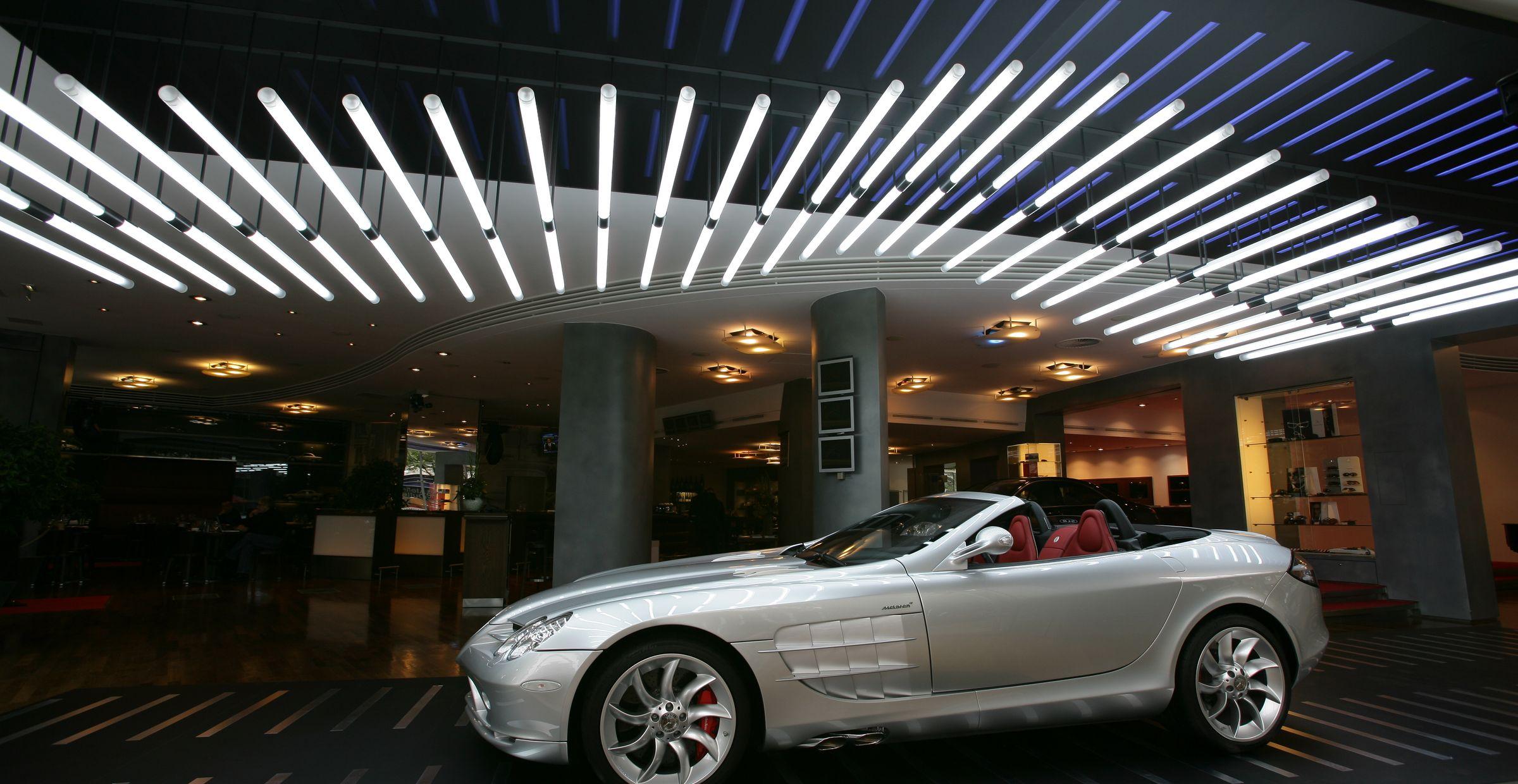 Silberner Mercedes SLR McLaren in modernem Showroom mit Lichtinstallation an der Decke