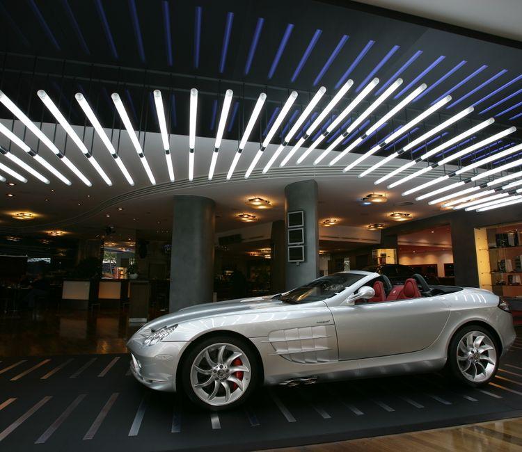 Silberner Mercedes SLR McLaren in modernem Showroom mit Lichtinstallation an der Decke