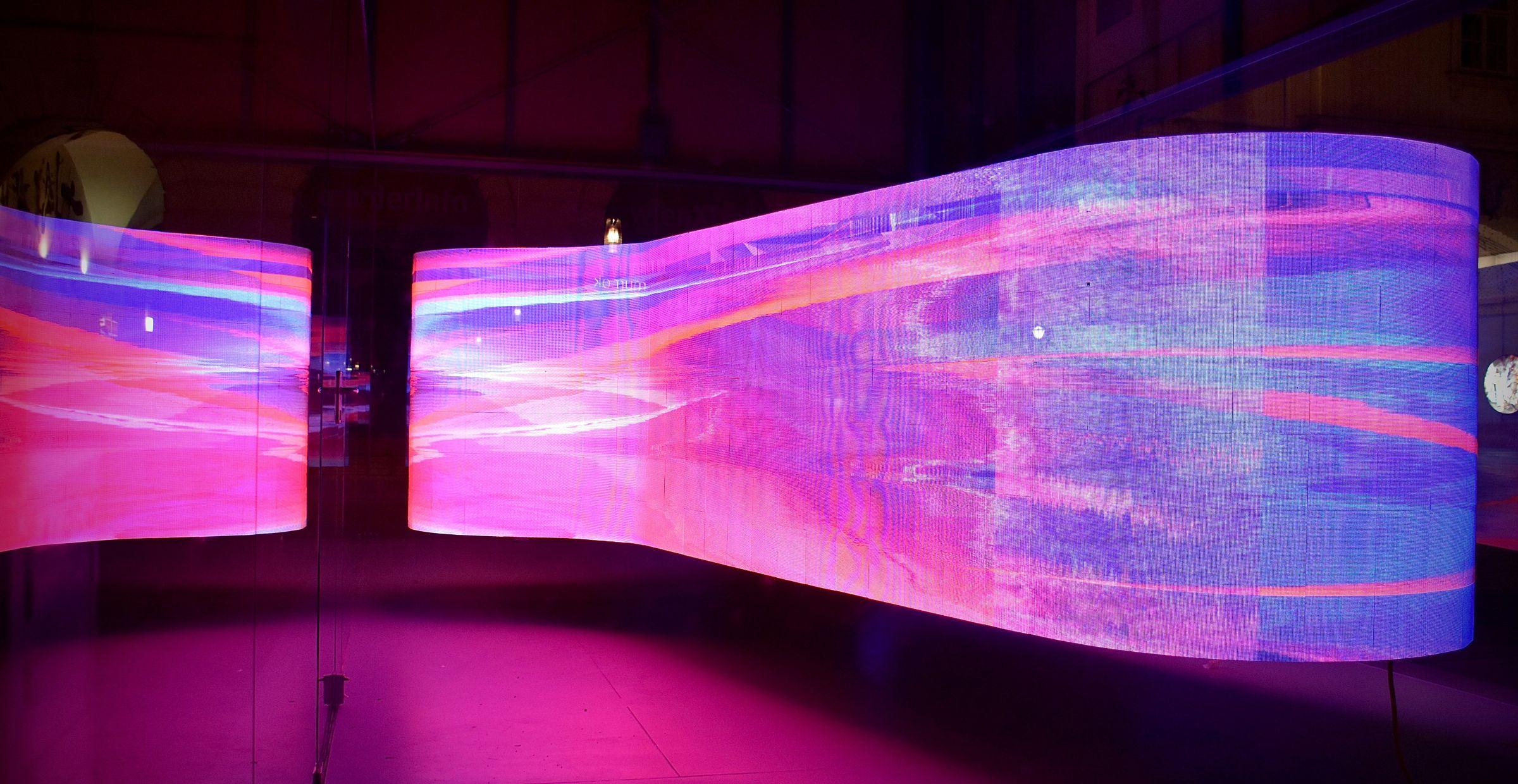 Eine gebogen LED-Wand, die ein pinkes Muster zeigt.