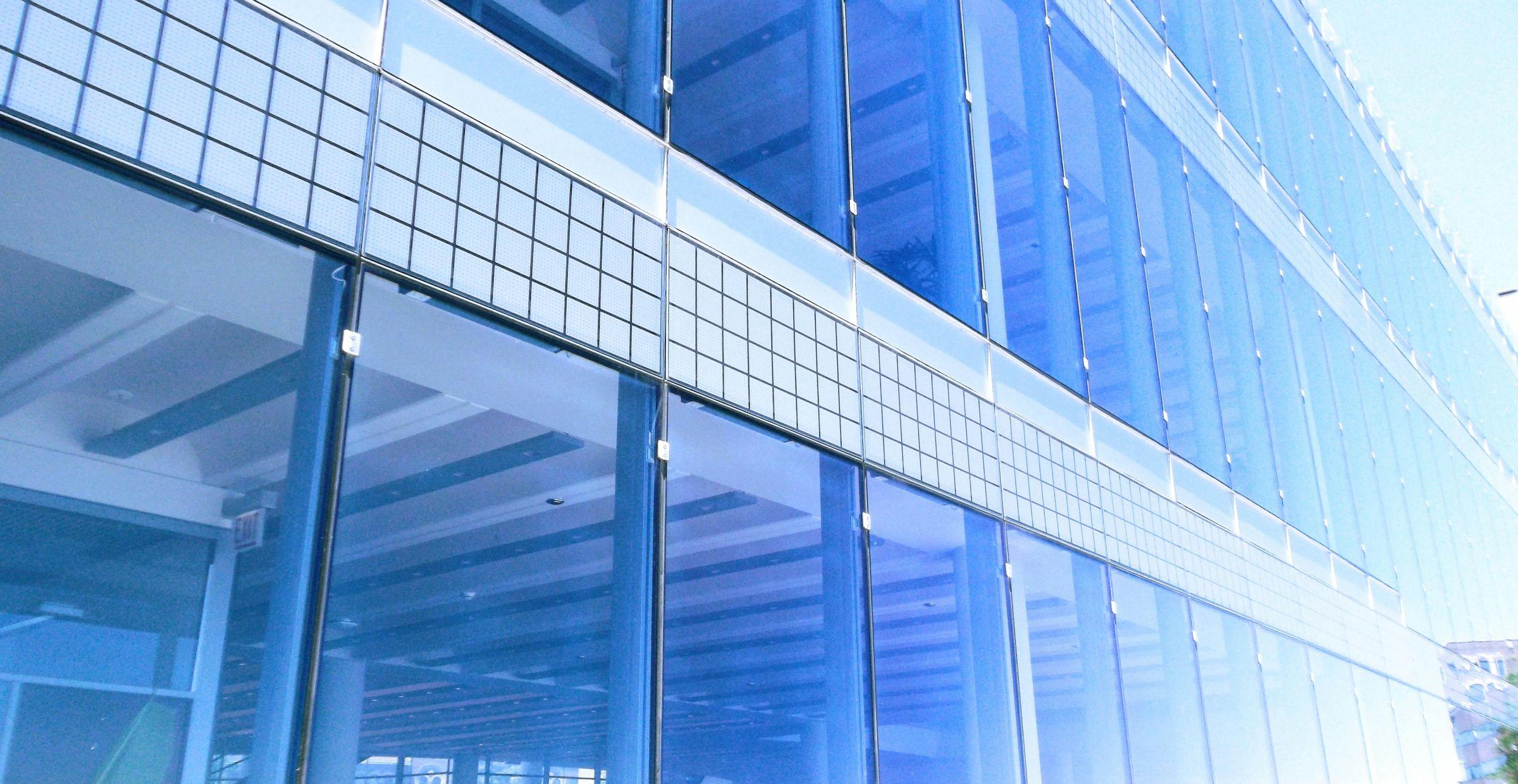 Eine Fassade aus Glas aus einer seitlichen Perspektive.