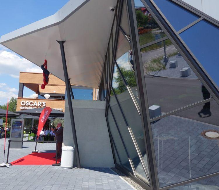 Detailansicht der polygonalen Glasfassade mit Spiderman-Dekoration am Eingang des Cineplex Neustadt.